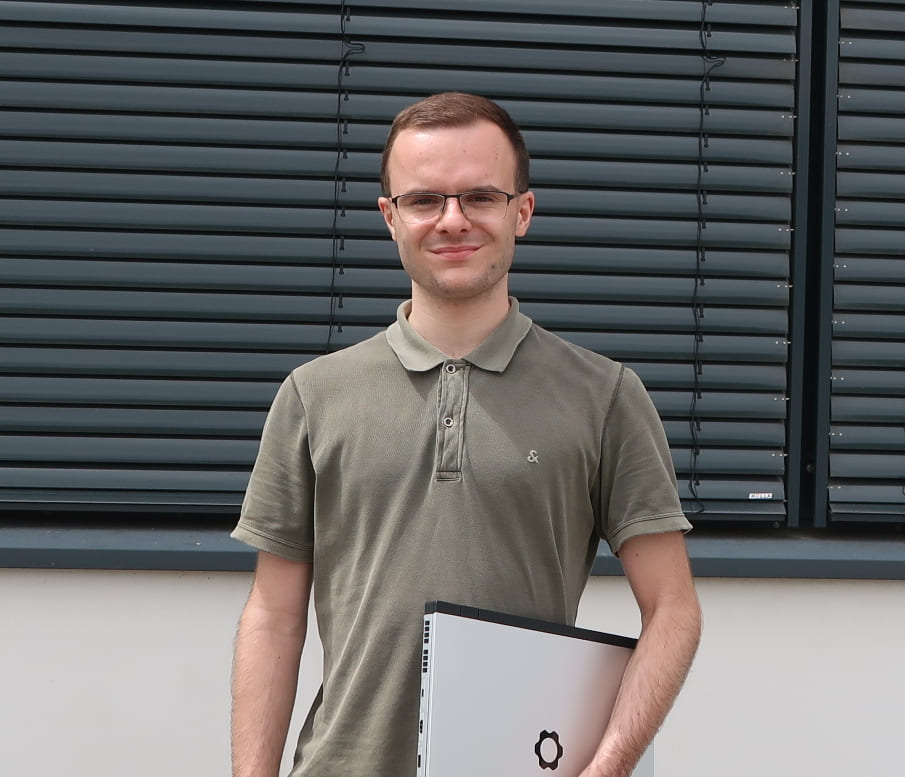 Paul Berz, Geschäftsführer von Berz Systems, mit seinem Notebook vor dem Bürogebäude